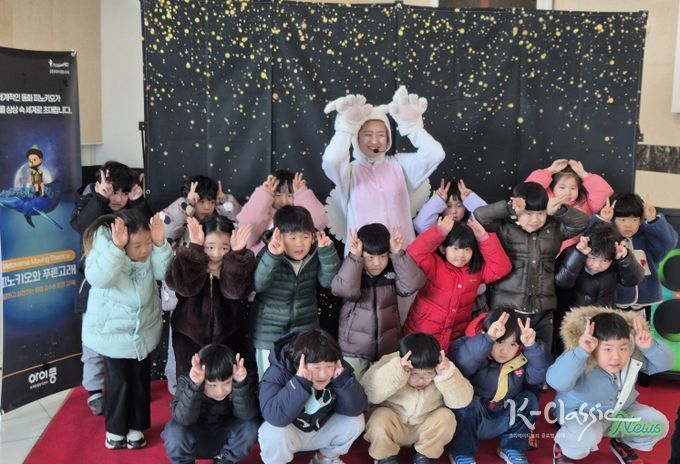 아이들이 공연 출연자와 함께 기념촬영을 하고 있다.