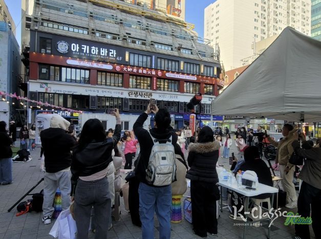 시민들이 인플루언서 크림서현과 랜덤댄스 챌린지 참여자들의 공연을 관람하고 있다.